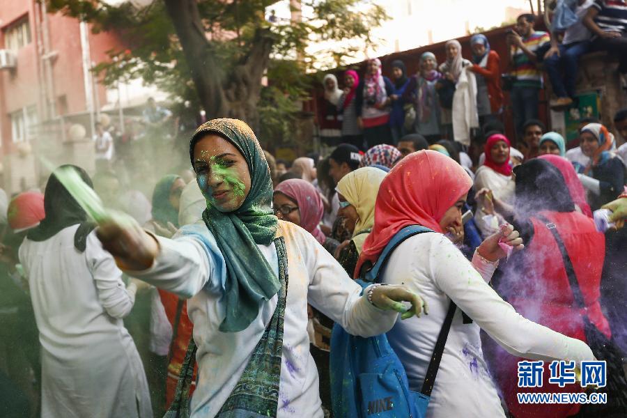 10月16日，在埃及首都開羅，一名女青年在“彩色跑”活動(dòng)中拋撒彩色粉末。