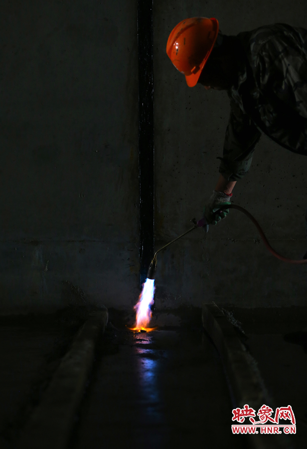 工人師傅用噴槍烘干地面，便于做防水處理