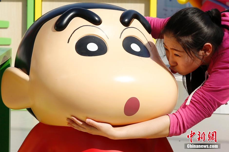 4月22日，游客與蠟筆小新合影?！跋灩P小新25周年紀(jì)念特展”日前在北京開(kāi)展，吸引了不少市民游客。