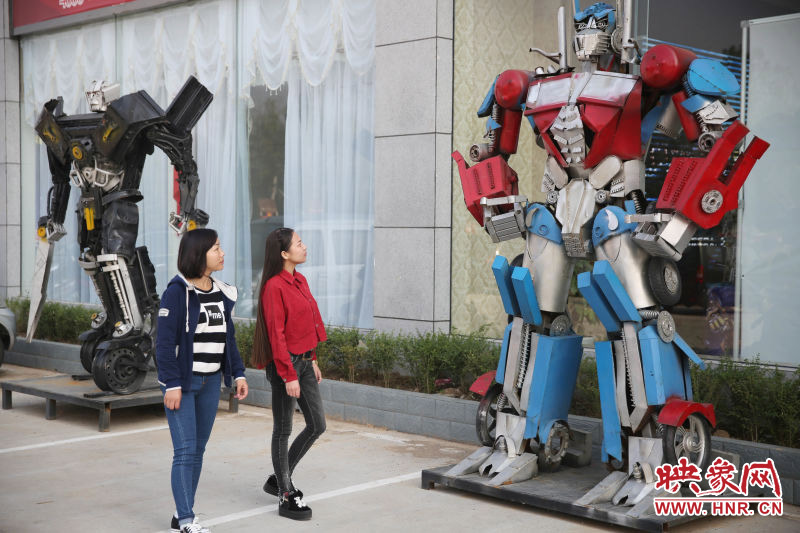 10月14日，市民在參觀河南省平頂山市寶豐縣一家企業(yè)門前的“變形金剛”。