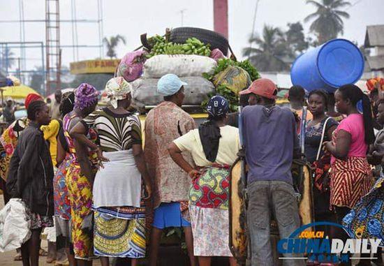 當?shù)貢r間2014年8月14日，利比里亞蒙羅維亞，市場里的商人們圍著一輛汽車。