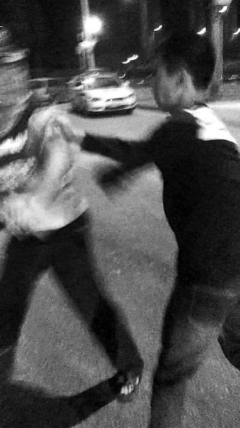 一名男子扯著民警的反光背心一路追打。