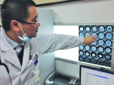 醫(yī)生在查看男孩的腦部CT片。薛馬義 攝
