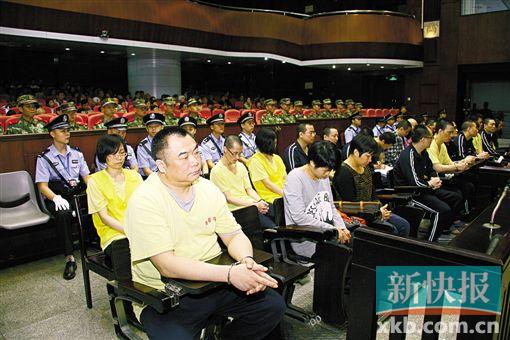 ■蔣洪偉(左一)等二十幾名被告被指控犯集資詐騙罪,昨日集體過(guò)堂?！　?鄭朝暉/攝