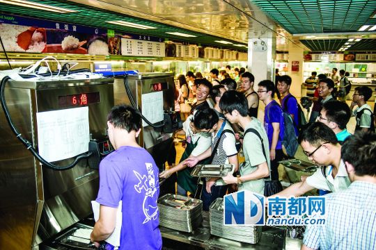 昨日，華南理工大學一食堂內(nèi)，學生們正在使用新安裝的自動打飯機打飯。中新社發(fā)