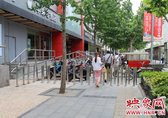 圖中道路左側(cè)的無(wú)障礙通道被鋼管隔離,右側(cè)的盲道也被侵占。