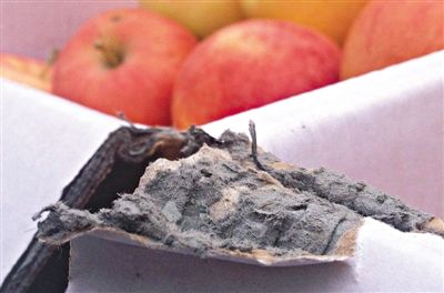 8月29日，新發(fā)地市場(chǎng)，一箱用“加重紙箱”包裝的蘋果正待售，紙箱夾層內(nèi)灰黑色的增重填充物清晰可見