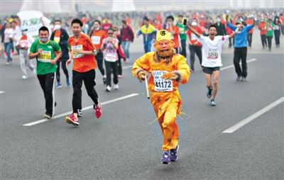 長(zhǎng)安街，一名打扮成孫悟空的參賽者在北馬隊(duì)伍里飛奔。 本版攝影/新京報(bào)記者 吳江 李飛 王嘉寧 吳江