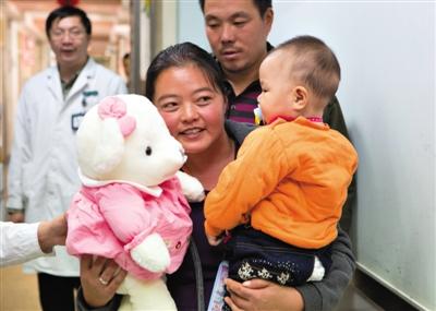 昨日上午，被扎針女嬰的母親抱著孩子和醫(yī)護(hù)人員送的玩偶準(zhǔn)備出院，院方稱孩子術(shù)后恢復(fù)良好。記者 高瑋 攝