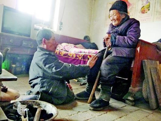 52歲的劉蘭山每天靠爬行照顧90歲的老母親。孫國(guó)祥 攝