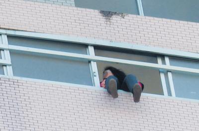 28樓的窗臺上坐著一名女子，其兩條腿耷拉在室外，不停地擺動。