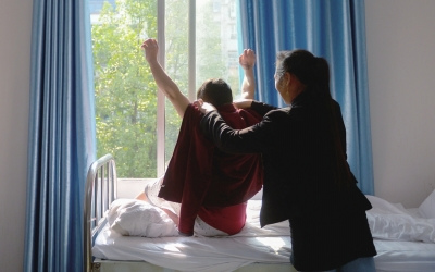 出院前，窗外透進(jìn)一道陽光，打在他的身上。