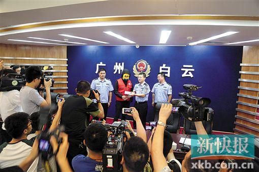 因舉報涉毒案件線索而獲獎的“快遞小哥”戴著面具領(lǐng)取獎金。