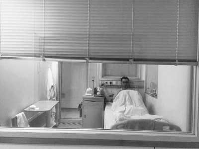 楊杰在醫(yī)院隔離病房中，沖記者揮了揮手。