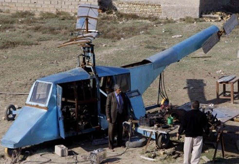 哈蒂姆·卡迪姆·薩爾曼正與工人交談，背后就是他正在制造的直升機(jī)