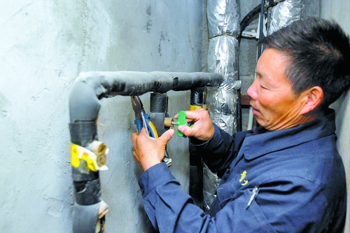 衛(wèi)運(yùn)宗師傅為御金城小區(qū)用戶(hù)開(kāi)啟供熱閥門(mén)