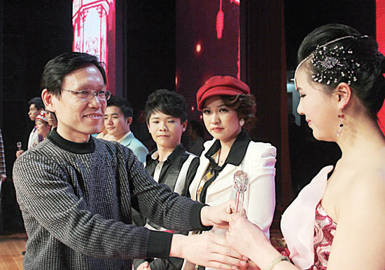 2013年2月1日，《對(duì)9當(dāng)歌》總決賽在鄭州開(kāi)唱。圖為東方今報(bào)副社長(zhǎng)胡楊為選手頒獎(jiǎng)