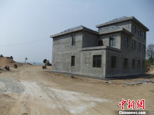 鴨河水庫庫區(qū)邊的新建別墅，一面墻上寫著“拆”，另一邊在加緊施工。吳揚　攝