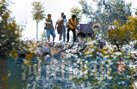 有人正在傾倒建筑垃圾，不遠(yuǎn)處就是村民的水井
